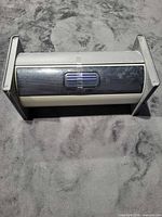 Closed gray roll-top CD/DVD storage box