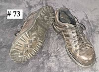 Pair of grey Merrell low-top shoes shown top and sole views