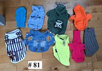 All nine dog garments laid out on floor