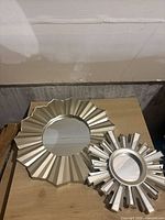 Both sunburst mirrors together showing relative sizes and frame designs