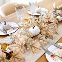 Table set with beige fall garland featuring leaves and white pumpkins