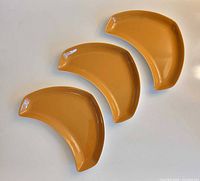 Three crescent dishes laid out flat