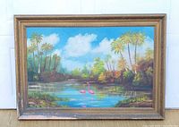 Full view of framed flamingo painting leaning against door