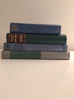 Stack of four hardcover books showing spines and bindings