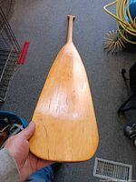 Full view of wooden canoe paddle blade and shaft