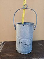 Front view showing full bucket, handle, and stenciled lettering