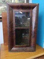Front view of mahogany-tone corner wall cabinet with glass door