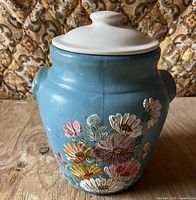 Front view showing blue ceramic jar and hand-painted flowers