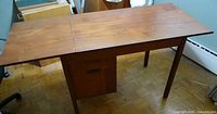 Top view of teak writing table with drop leaf extended showing overall design