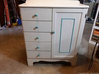 Front view showing five drawers with blue knobs and right door