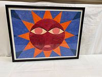 Front view of framed abstract sun face artwork
