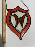 Full view of stained glass shield panel with ruler for scale