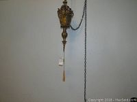 Two ornate vintage hanging lamps with metal scrollwork, glass panels, and long chains shown hanging from ceiling.