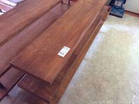 Photo of top and middle shelves of wooden bookshelf, showing polished wood surface and natural grain.