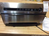 Front view of the FoodSaver V3825 vacuum sealer showing stainless steel finish, control buttons, and power cord.