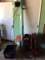 Photo showing project screen stand leaned against wall with Honeywell air purifier box and heater in foreground. Also visible are parts of wooden TV trays.