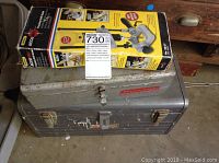 Photo showing vintage Sears Craftsman metal toolbox with wear and a box of Porter Cable Precision Drill Guide resting on top.