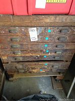 Wooden tool chest showing six drawers with metal pull handles and a worn finish.