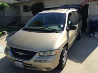 Front view showing grille, headlights, windshield, hood of gold minivan