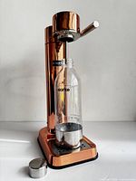 Front view of carbonator with bottle inserted and cap on base
