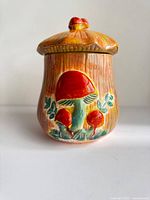 Front view of ceramic jar showing mushroom design and lid