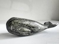 Left view of soapstone whale showing overall form and incised eye