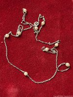 Full view of the necklace laid out showing chain style, bead placement, clasp