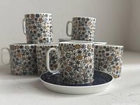 Front view showing two cups on saucers, additional cups and saucers behind