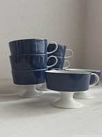 Stack of four straight cups with two pedestal cups showing color and form