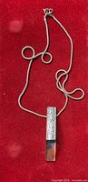 Full view of sterling chain and prism pendant on red background