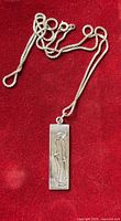 Full view of pendant necklace on red background