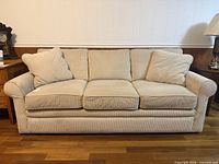 Front view of beige corduroy sofa with three seat and back cushions