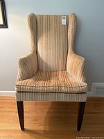 Front view of striped velvet wingback chair