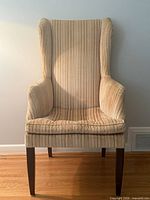 Front view of striped corduroy wingback chair showing full height and upholstery