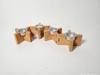 Front angled view showing assembled candle holder with four wood blocks and aluminum cups