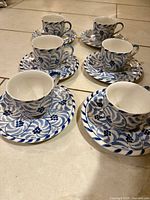 All six cups with saucers arranged on floor