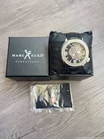 Watch in original box next to sealed booklet