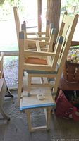 Four stacked child-size chairs, cream paint with blue accents