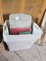 Nested off-white plastic totes with lids and red cube inside