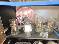 Cabinet shelf with IVB beer mugs, goblet trophy, crystal award, trays and figurine