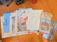 Stack of brochures showing Mexico, Florida flamingo, Watch & Clock Collectors bulletin, Philadelphia Esso map