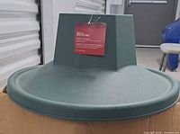 Green plastic tree stand with tag attached