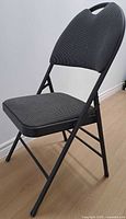 side view of padded folding chair showing overall design