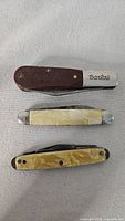 All three knives closed, showing handles and Barlow stamp