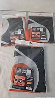 Three sealed Philadelphia Flyers flags in retail packaging