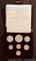 Open presentation case showing seven coins and specification card