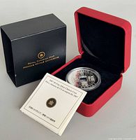 Coin in capsule inside red case with COA and outer box