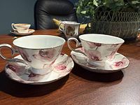 Two orchid-pattern teacups on matching saucers