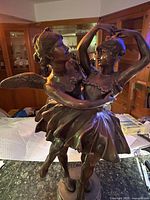 Front view of bronze sculpture showing both ballerinas, tutus, and wings