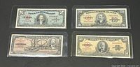 Four Cuban banknotes in sleeves, showing denominations 1,10,20,50